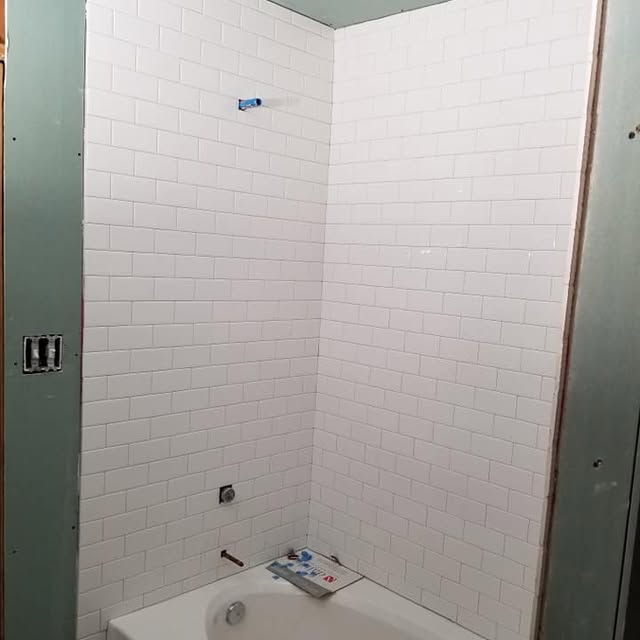 Bathroom remodel Weatherford TX – newly tiled bathtub and shower wall installation by Prestige Plumbing & Construction.